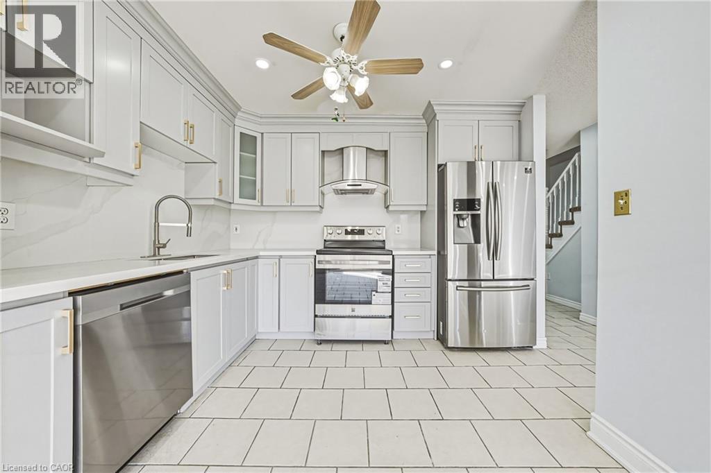 A white kitchen with a fan on the ceiling.