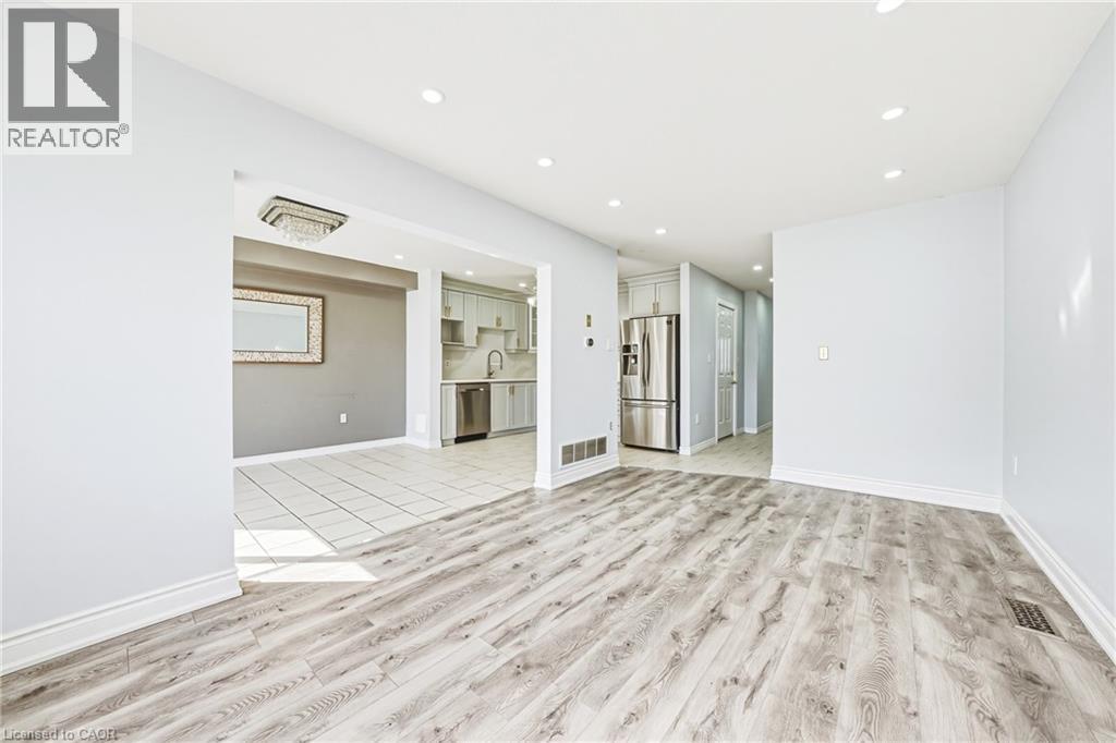 A spacious room with a wooden floor and white walls.