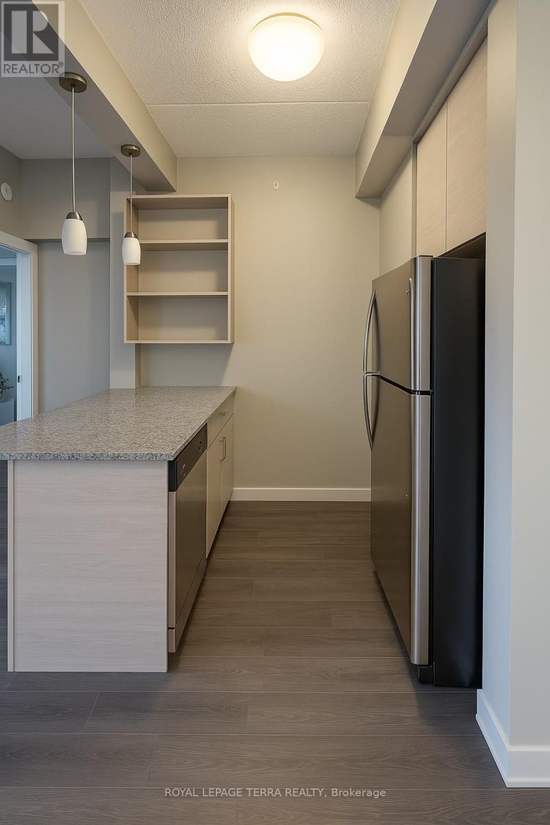 A kitchen with a black refrigerator and a granite counter top.