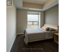 A bedroom with a bed, nightstand, and window.