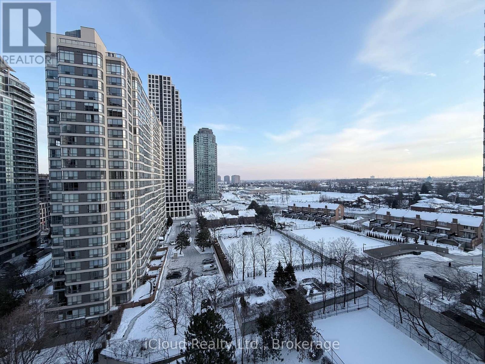 A cityscape with tall buildings and a snow-covered ground.