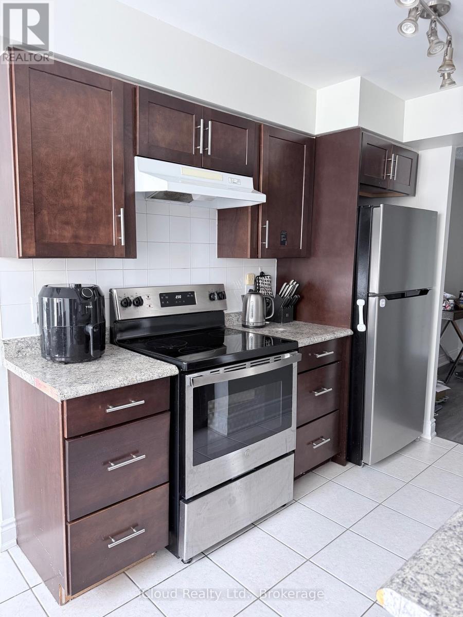 A kitchen with brown cabinets and a stainless steel refrigerator.