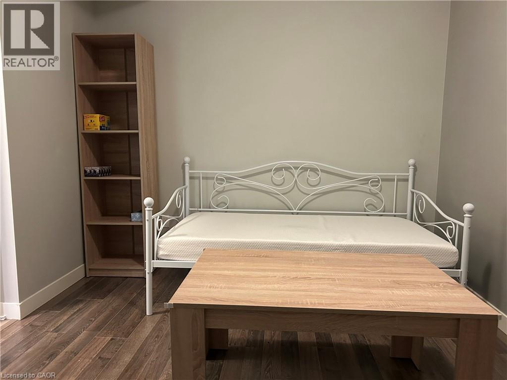 A bedroom with a white metal bed and a wooden table.