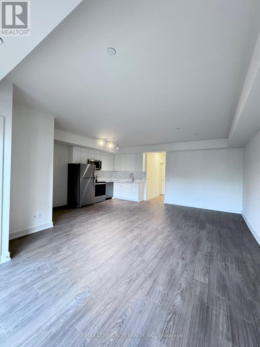 A spacious room with a grey floor and white walls.