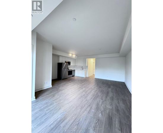 A spacious room with a grey floor and white walls.