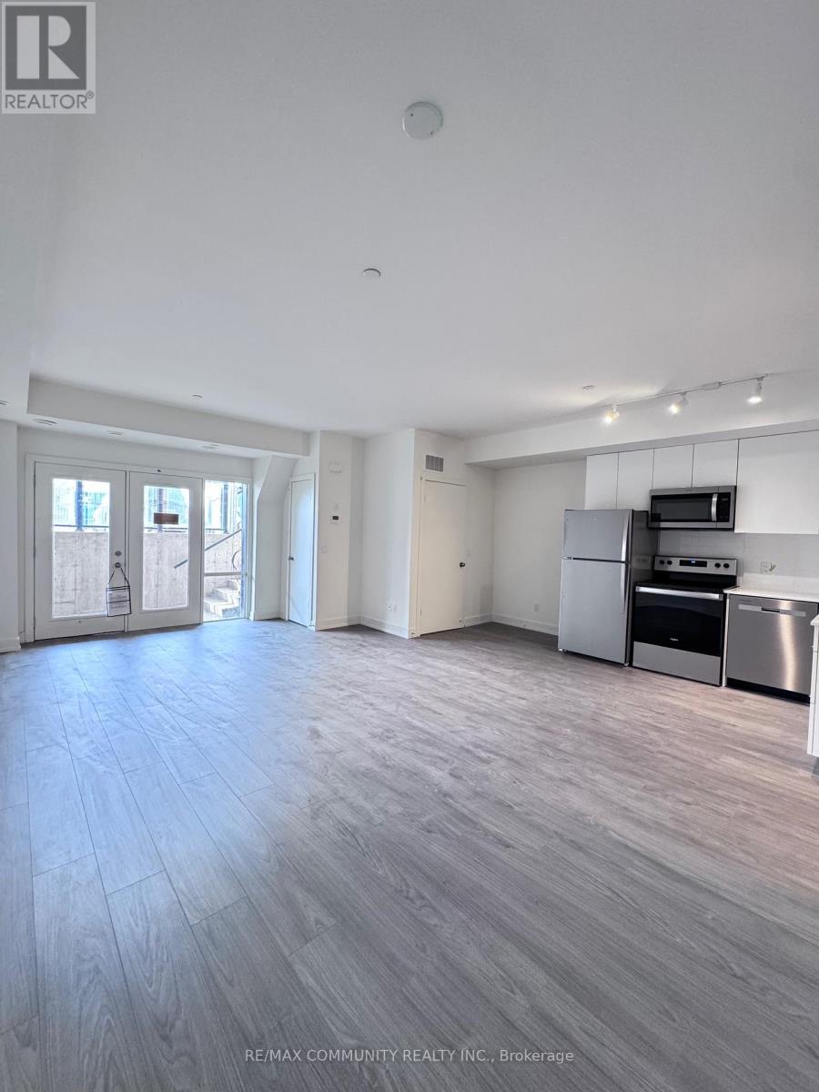 A spacious kitchen with stainless steel appliances and a dining area with a table and chairs.