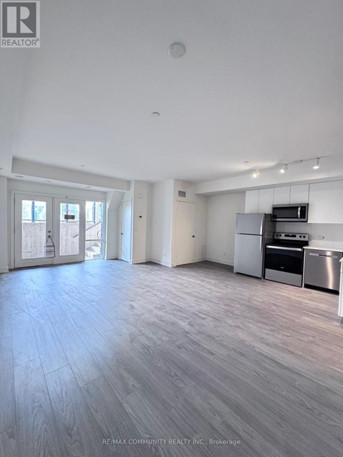 A spacious kitchen with stainless steel appliances and a dining area with a table and chairs.