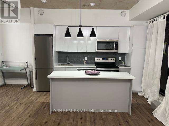 A kitchen with white cabinets and a white island with a countertop.