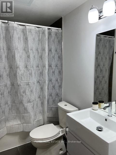 A white toilet sits next to a sink in a bathroom.
