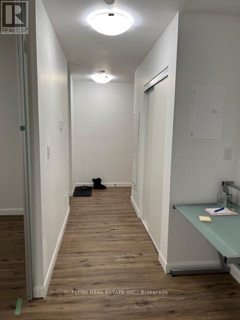 A long hallway with a desk and a door at the end.