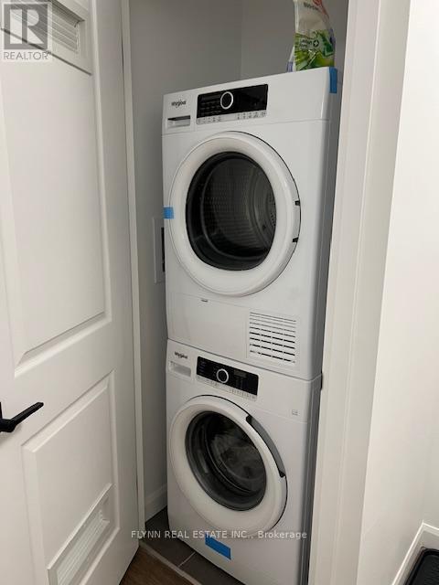 A white dryer and washer are stacked on top of each other.