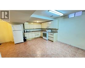 A kitchen with white appliances and brown tile flooring.