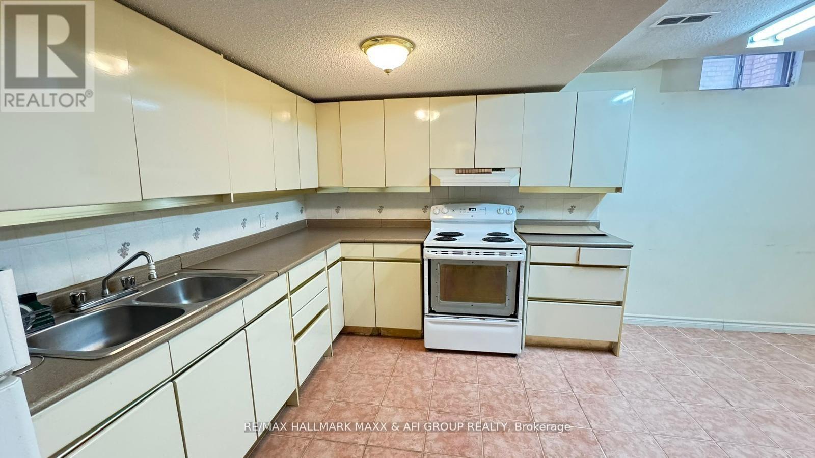 A kitchen with white cabinets and a white stove top oven.