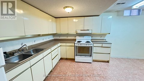 A kitchen with white cabinets and a white stove top oven.