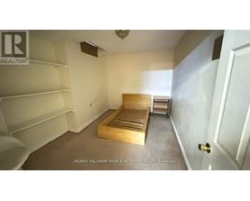 A bedroom with a bed, shelves, and a door.