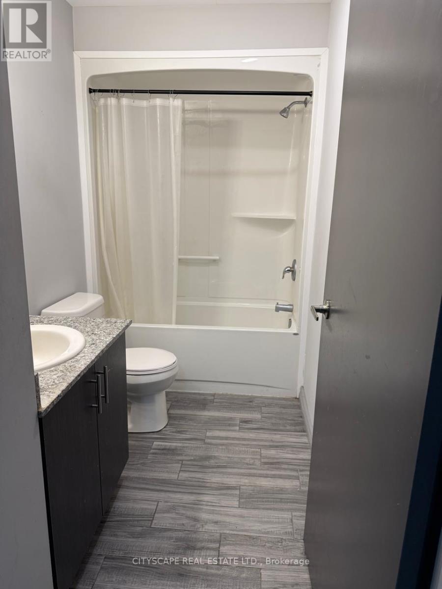 A bathroom with a toilet, sink, and shower.