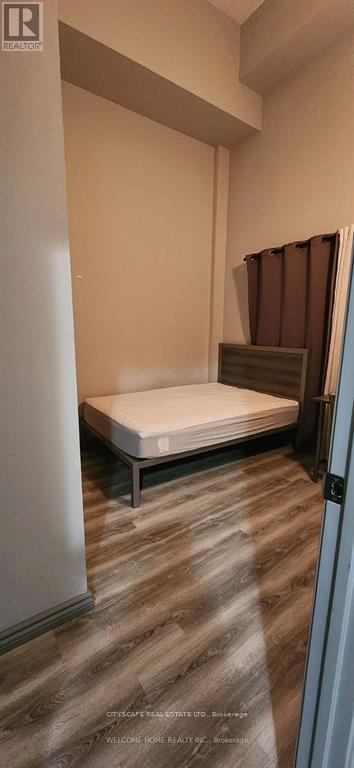 A bedroom with a bed and a wooden floor.