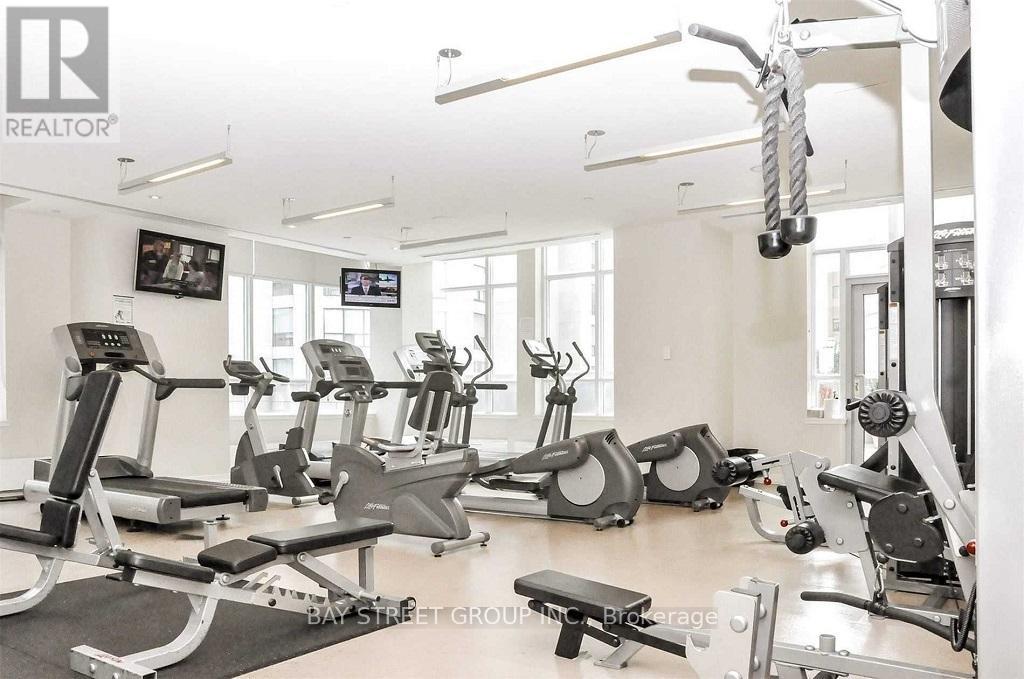 A gym with a variety of exercise equipment including treadmills, stationary bikes, and weight machines.
