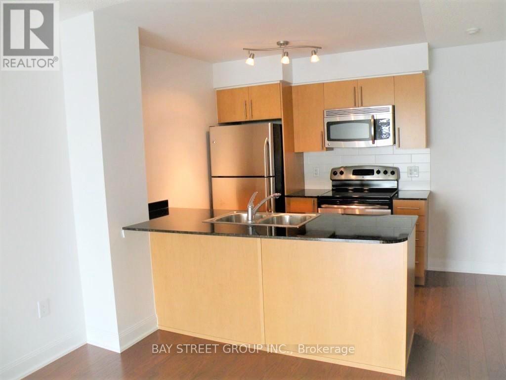 A kitchen with wooden cabinets and a black countertop.