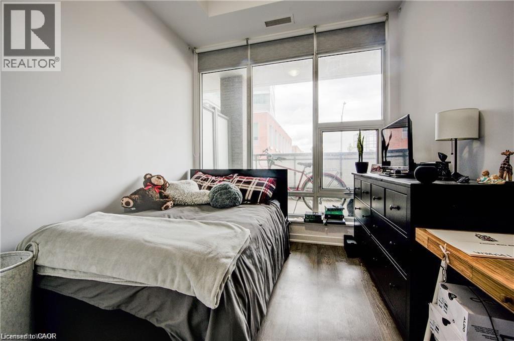 A bedroom with a bed, dresser, and window.