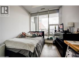A bedroom with a bed, dresser, and window.