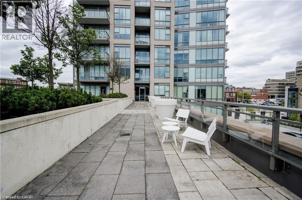 A balcony with two chairs and a table is in front of a building with the word REALTOR on it.