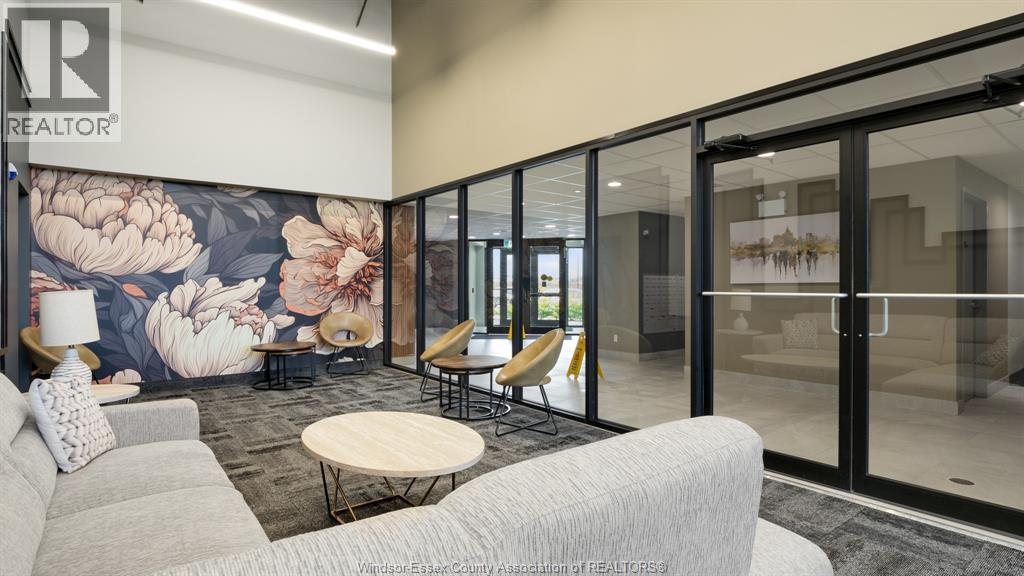 A modern office space with a floral mural on the wall and glass walls leading to another room.