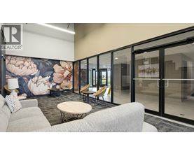A modern office space with a floral mural on the wall and glass walls leading to another room.