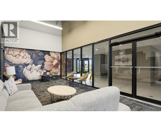 A modern office space with a floral mural on the wall and glass walls leading to another room.