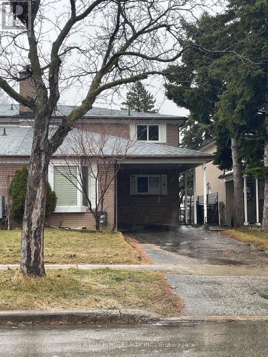 A house with a grey roof and a tree in front of it.
