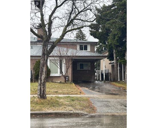 A house with a grey roof and a tree in front of it.