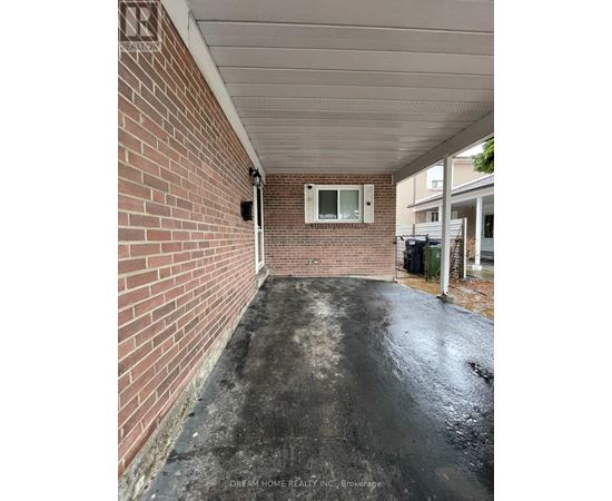 A brick wall with a window and a door in the background.