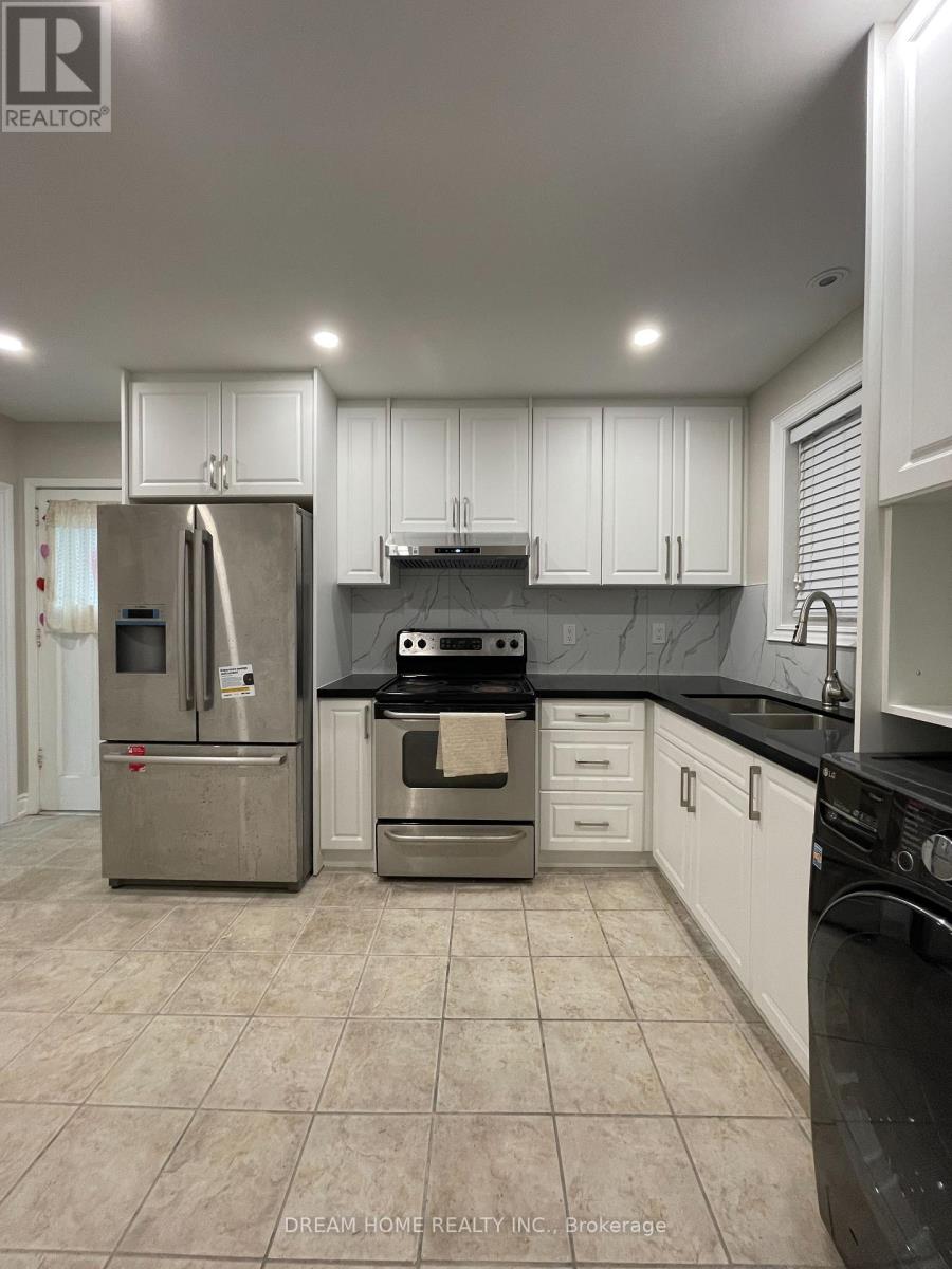 A kitchen with white cabinets and a black countertop.