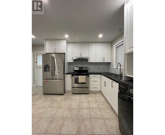 A kitchen with white cabinets and a black countertop.