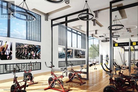 A gym with exercise bikes and a wall of pictures of people exercising.