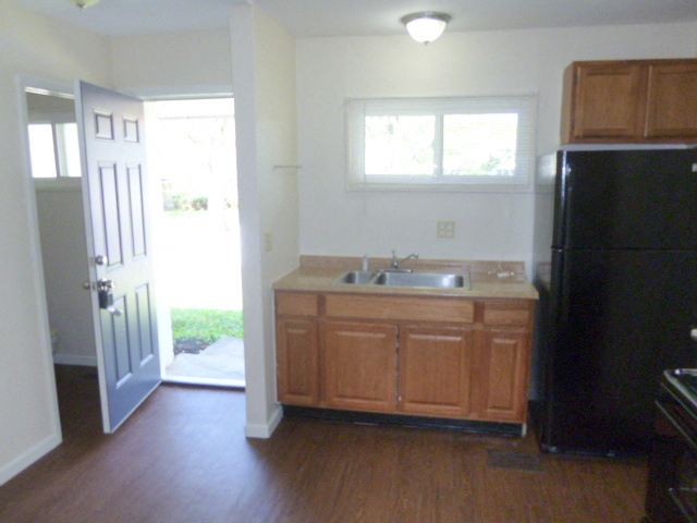 an empty kitchen with a sink and a refrigerator