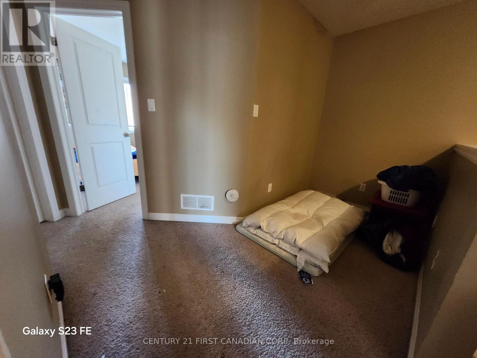 A bedroom with a bed and a trash can.