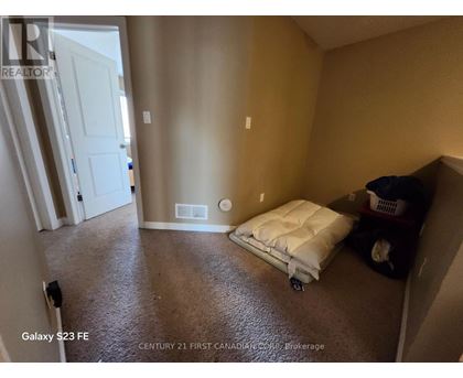 A bedroom with a bed and a trash can.