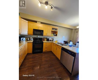 A kitchen with wooden cabinets and a black oven.