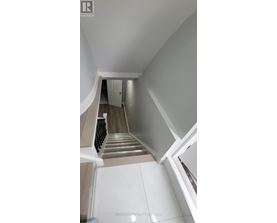 A staircase with a white railing and a white door at the top.