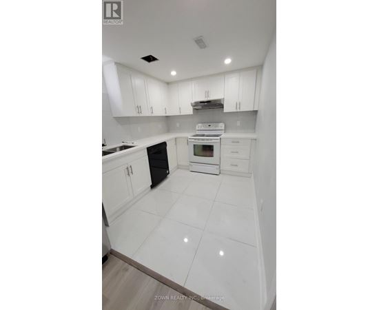 A white kitchen with a black oven and white cabinets.