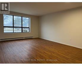 A room with wooden flooring and a large window.