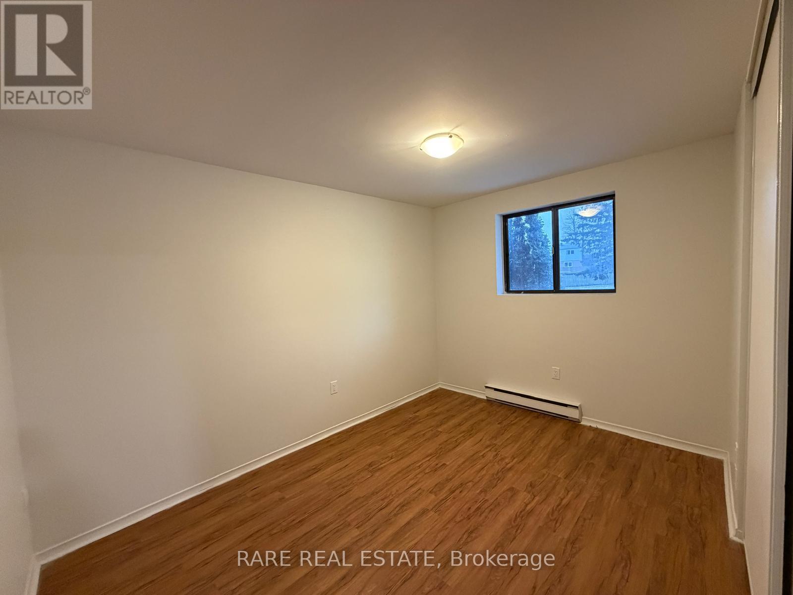 A room with a window and a wooden floor.
