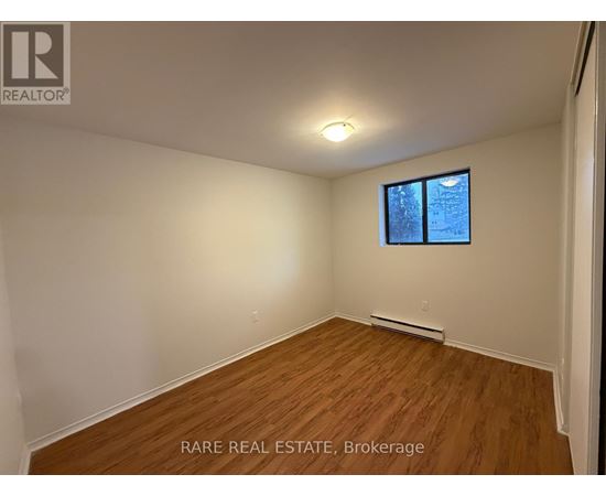 A room with a window and a wooden floor.