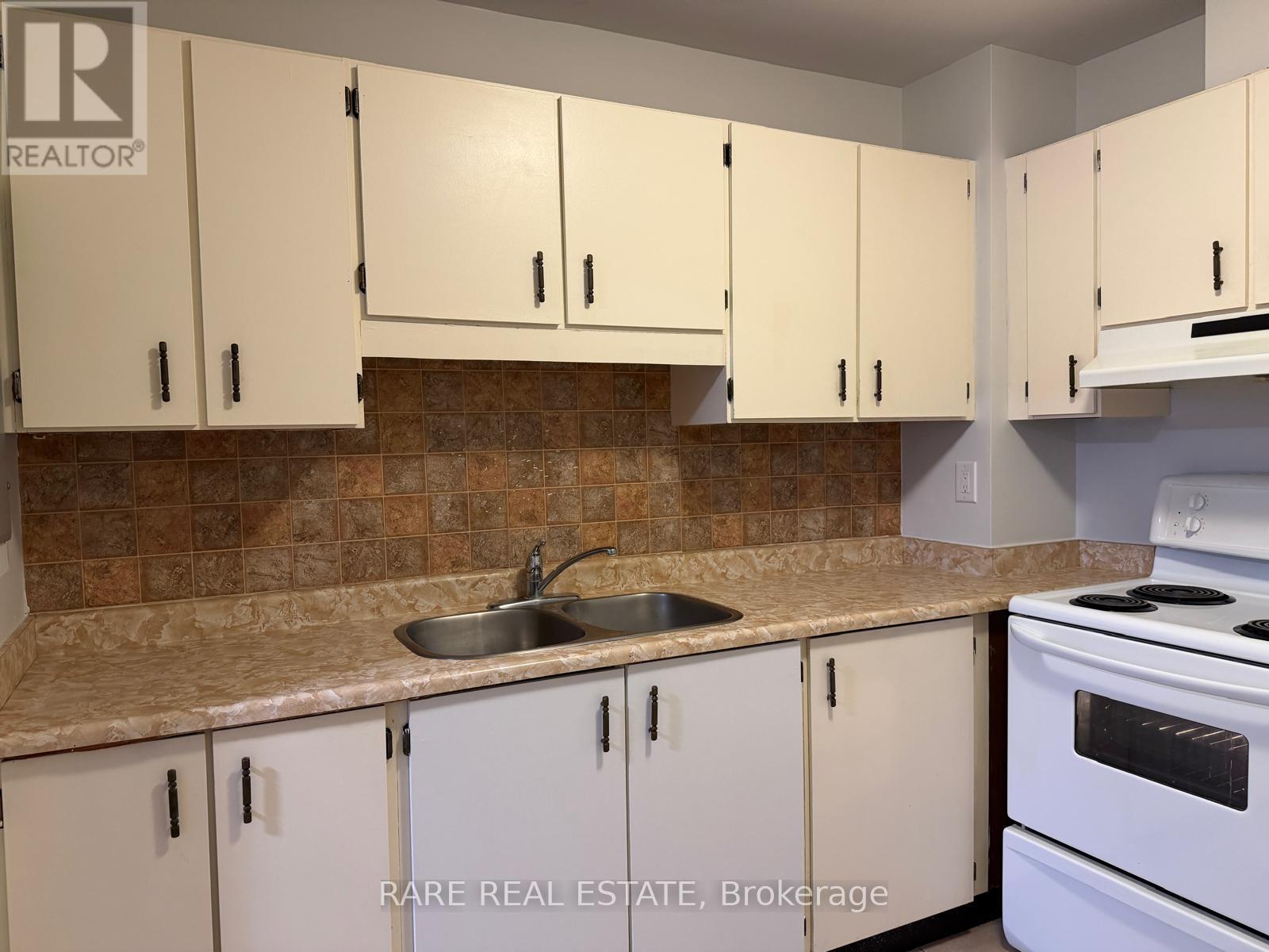 A kitchen with white cabinets and a white stove.