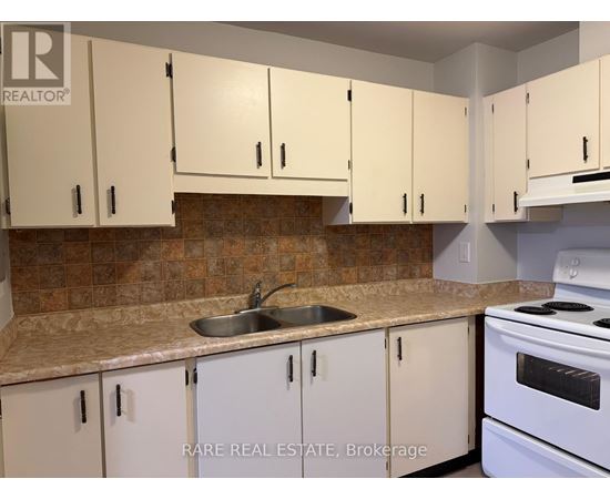 A kitchen with white cabinets and a white stove.