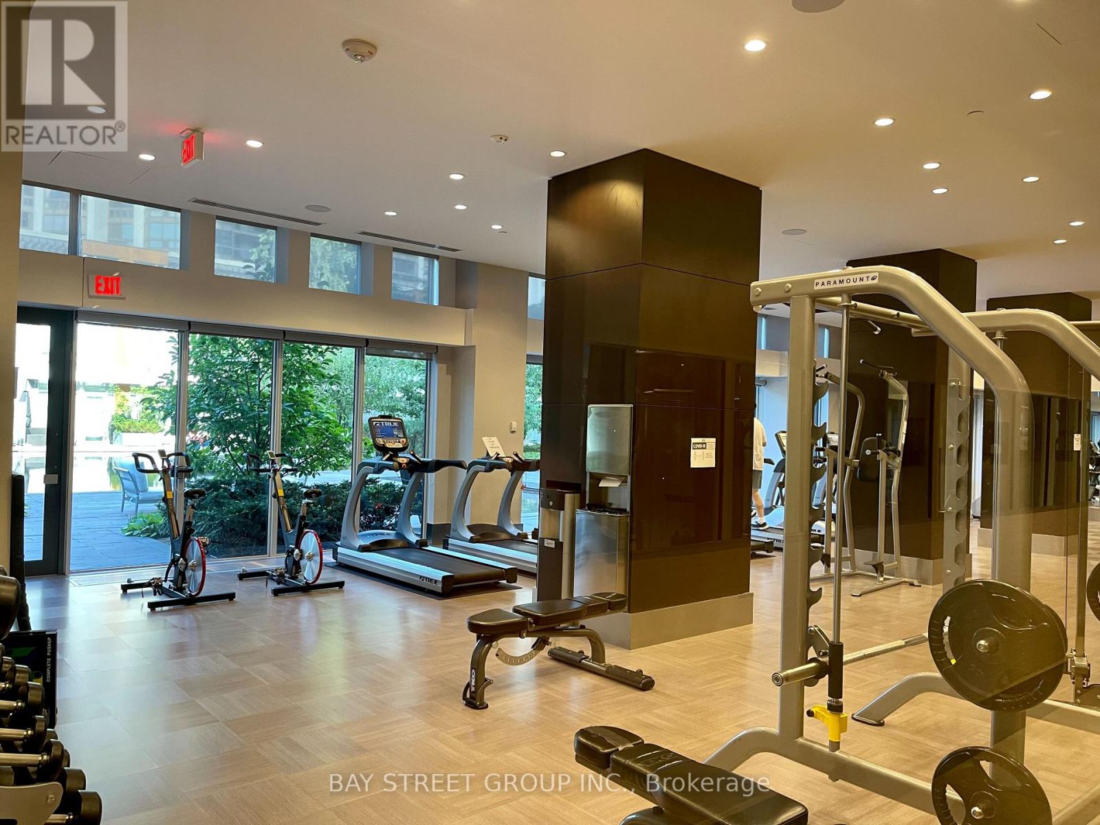 A gym with a variety of equipment including treadmills, weights, and exercise bikes.