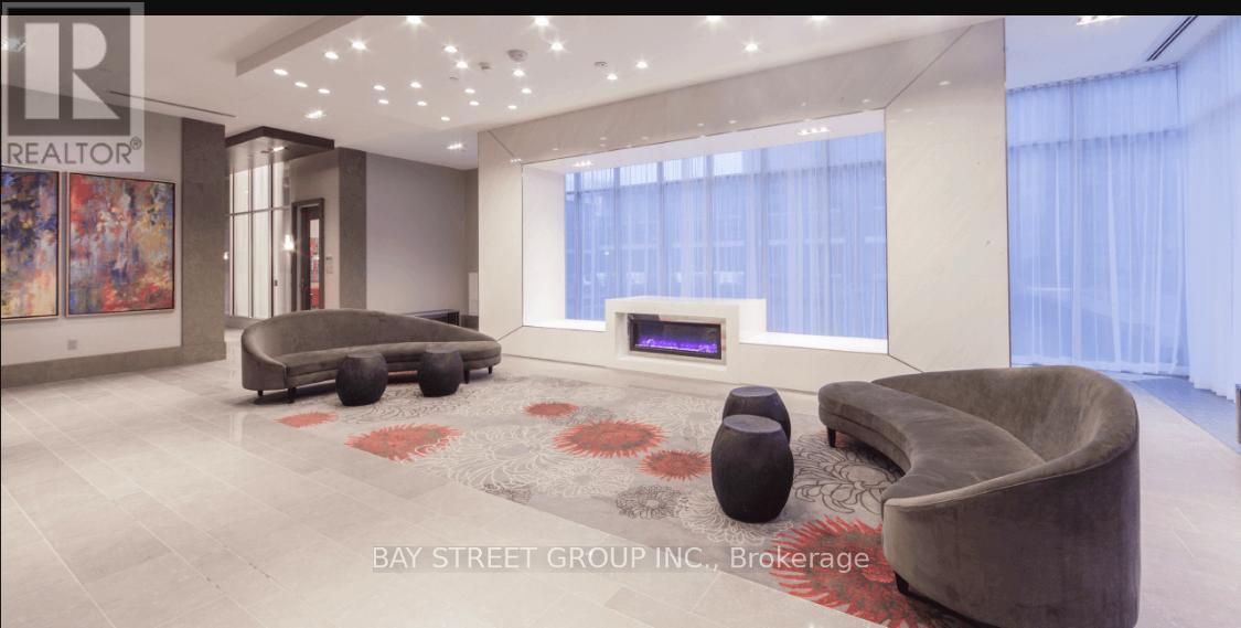 A living room with a grey sofa and a black ottoman.