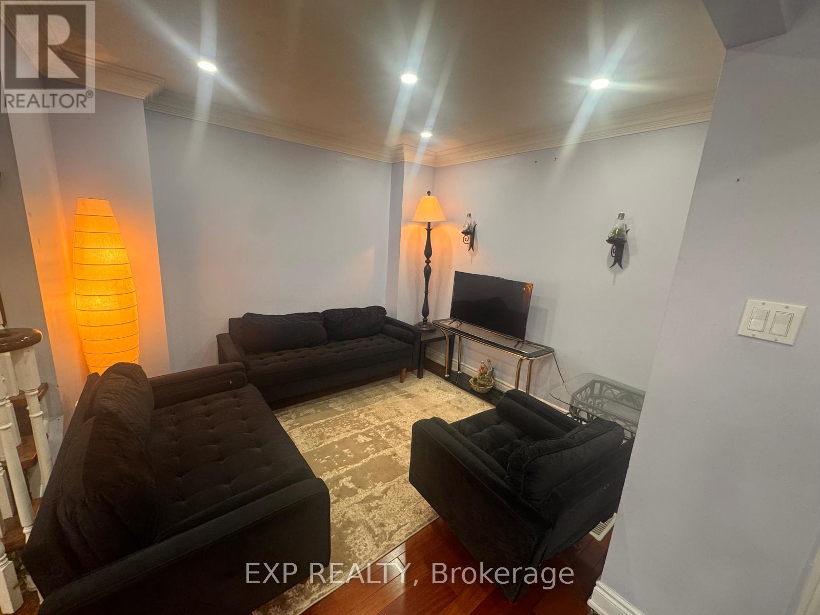 A living room with black furniture and a television.