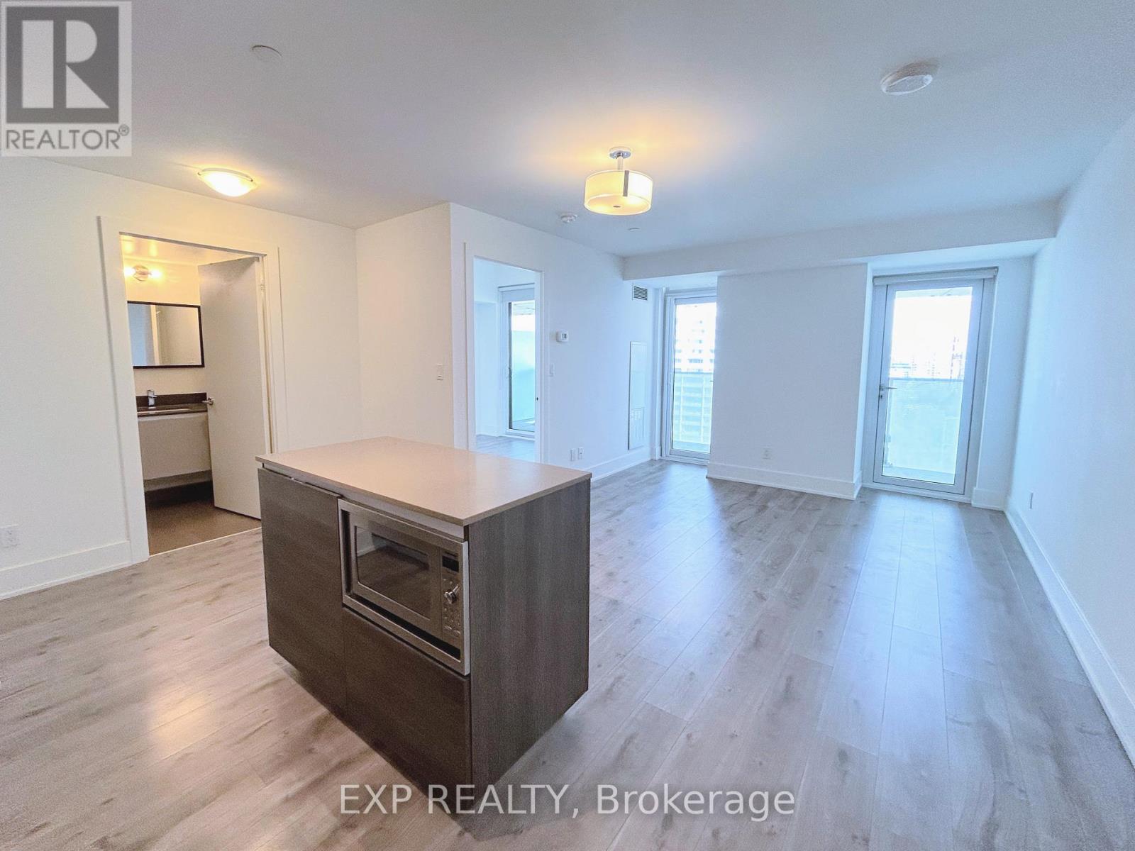 A spacious room with a built-in oven and wooden flooring.